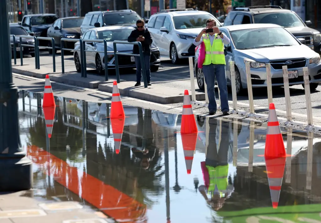 People photograph high tide flooding along the Embarcadero in San...