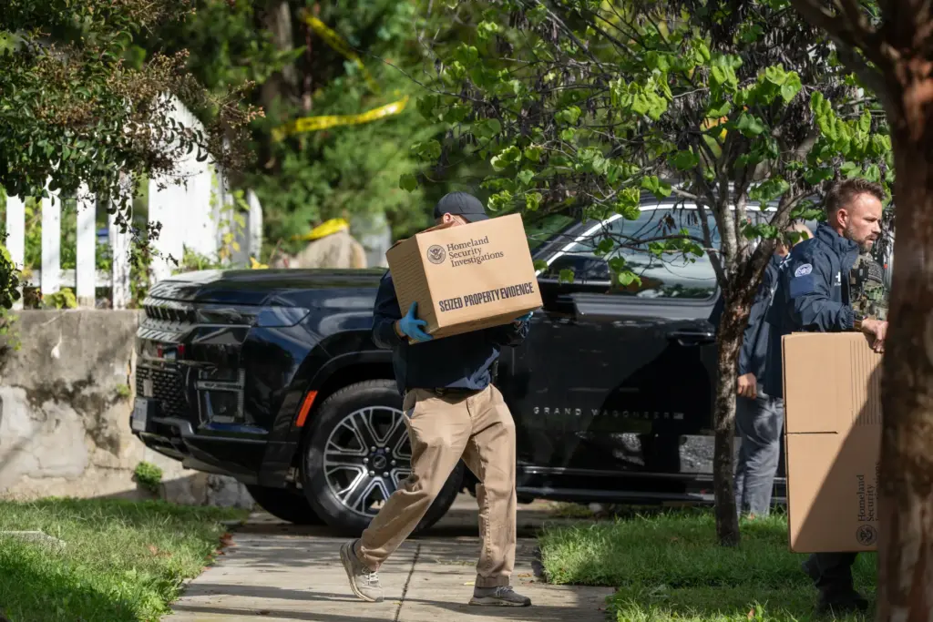 Homeland Security officers carry boxes from the Washington residence of Rep. Ilhan Omar.